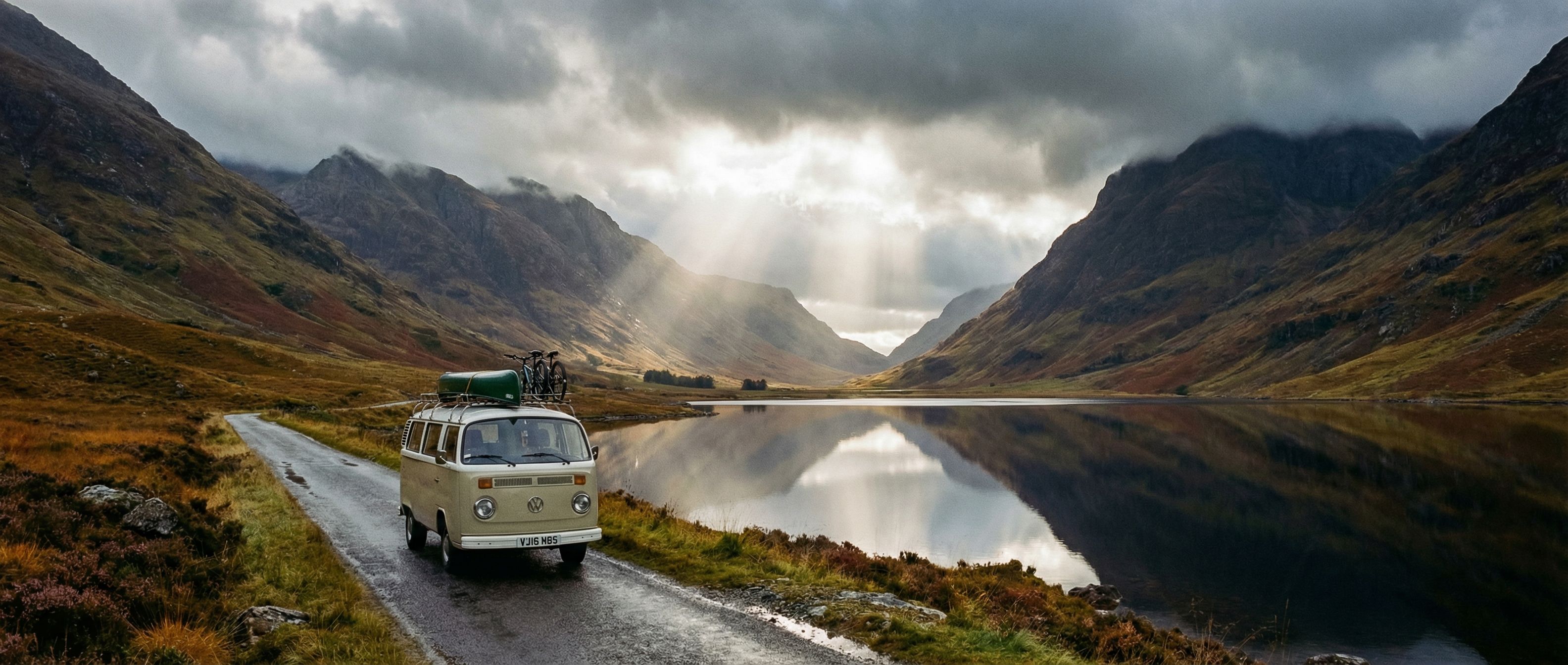 Route sinueuse à travers les Highlands écossais avec montagnes en arrière-plan